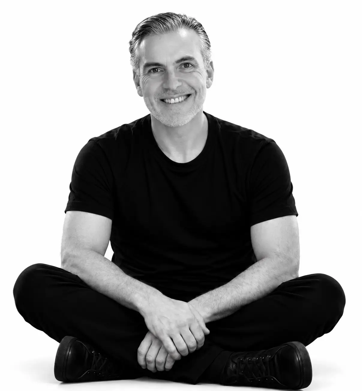 Daniel Bogo sentado, sorrindo, em fotografia em preto e branco